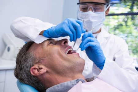 man smiling sitting in dentist chair