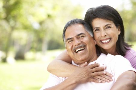 Smiling couple with dental implants in summertime