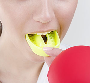 a person inserting an athletic mouthguard