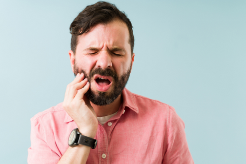 Man in pain with a toothache portraying ibuprofen use and need for an emergency dentist