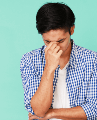 Young man with his head down portraying disappointment over an unnecessary tooth extraction